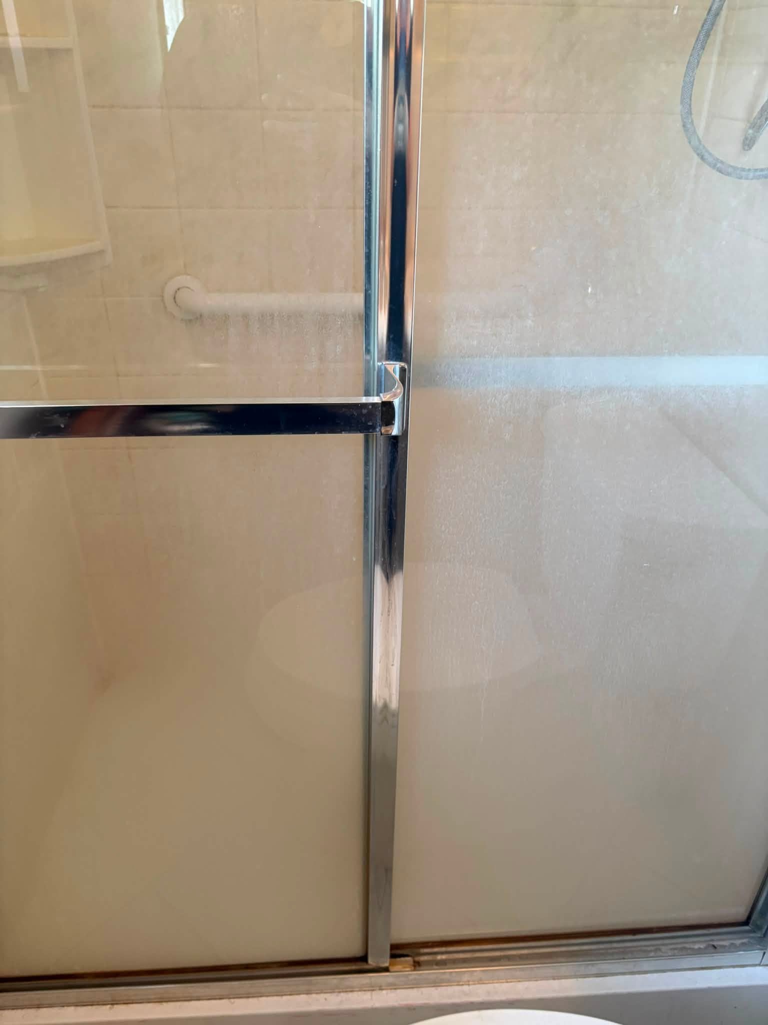 Shower glass before the clean, cloudy with soap scum
